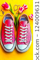 Bright spring vibes with stylish sneakers and cheerful tulips on a sunny yellow backdrop 124009631