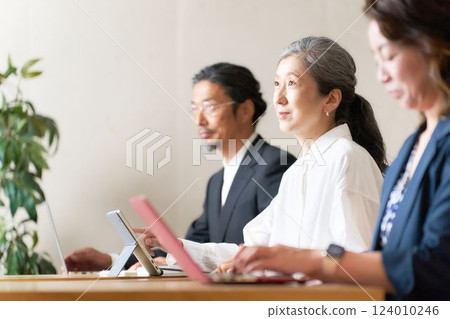 Middle-aged men and women attending a seminar 124010246