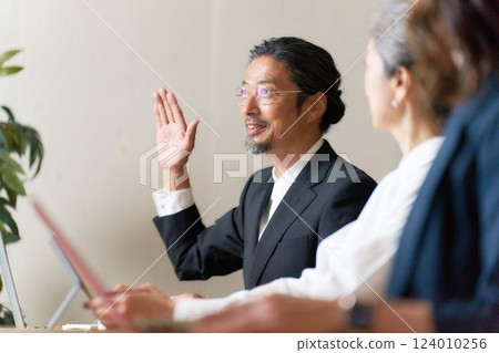 Senior man raising his hand to speak 124010256