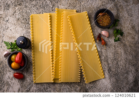 Uncooked lasagna pasta with cooking ingredient 124010621