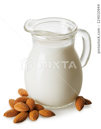 almond milk in glass jug and pile of nuts isolated on white background 124010944