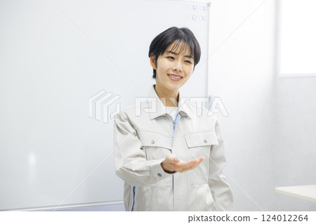 A woman in work clothes giving a presentation in a conference room A woman in work clothes giving a presentation in a conference room 124012264