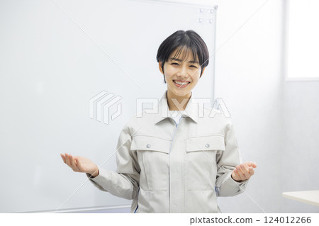 A woman in work clothes giving a presentation in a conference room A woman in work clothes giving a presentation in a conference room 124012266