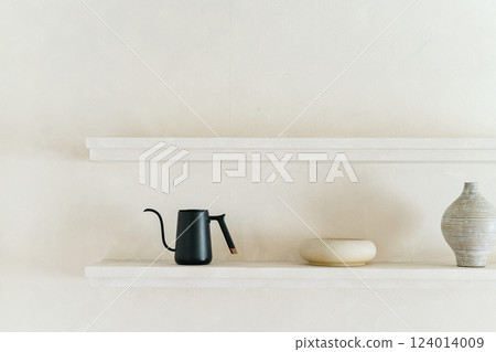 Minimalist black kettle and ceramic vase on white shelves Minimalist black kettle and ceramic vase on white shelves 124014009