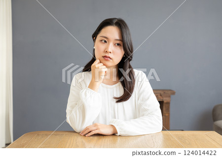 Asian woman thinking in the living room 01 124014422