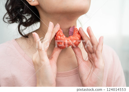 Hyperthyroidism, Overactive Thyroid, Thyroid Lymphoma, Asian woman with thyroid gland human anatomy model. 124014553