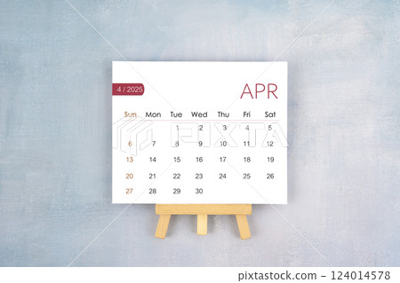 April 2025 calendar page with wooden easel. April 2025 calendar page with wooden easel. 124014578