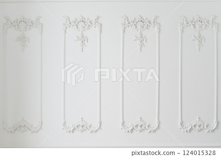 Elegant white wall with ornate decorative moldings 124015328