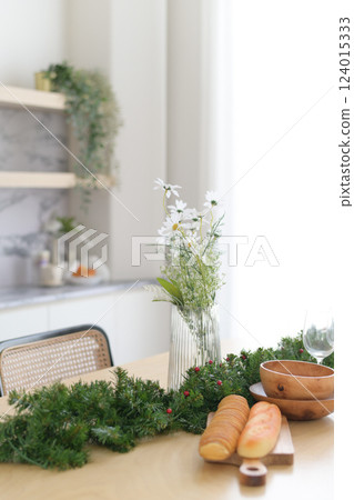 Festive table with bread, greenery, and flowers in vase Festive table with bread, greenery, and flowers in vase 124015333