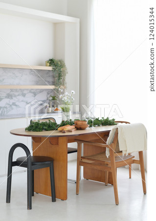 Modern dining table with wooden chairs and greenery decor Modern dining table with wooden chairs and greenery decor 124015344