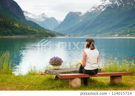 Woman tourist relaxing on fjord sea shore, Norway 124015724