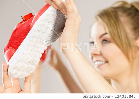 Happy woman presenting sportswear trainers shoes 124015845