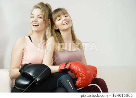 Two women friends wearing boxing gloves Two women friends wearing boxing gloves 124015865
