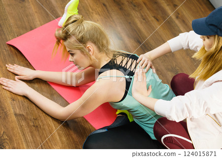 Woman in sportswear doing workout with trainer Woman in sportswear doing workout with trainer 124015871