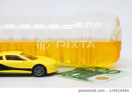 A bottle of vegetable oil and a typewriter lie on a banknote. Biodiesel, biofuel, vegetable oil 124016464