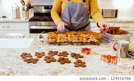 After baking to perfection, these delightful gingerbread cookies are now cooling gracefully on a wire rack, filling the modern kitchen with a warm and inviting aroma. After baking to perfection, these delightful gingerbread cookies are now cooling gracefully on a wire rack, filling the modern kitchen with a warm and inviting aroma. 124016766