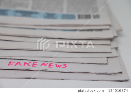 A stack of newspapers with the inscription fake news, corrupt journalism. 124016874