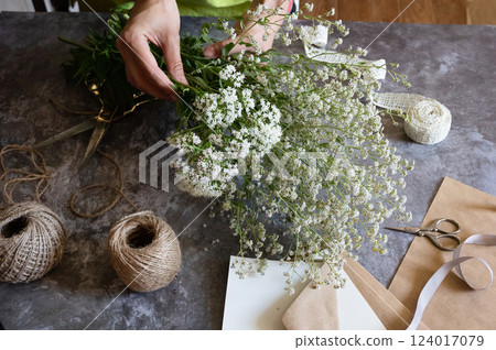 Crafting with natural elements using freshly picked flowers in a creative workspace Crafting with natural elements using freshly picked flowers in a creative workspace 124017079