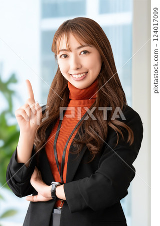 A smiling woman/businesswoman pointing with her index finger up 124017099