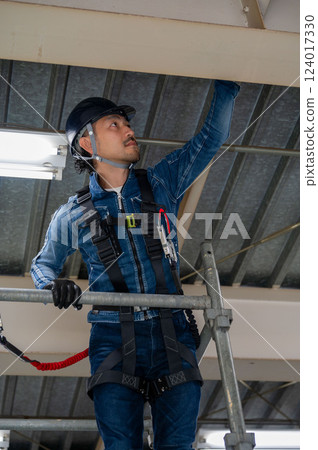 A man performing inspection work at a height 124017330
