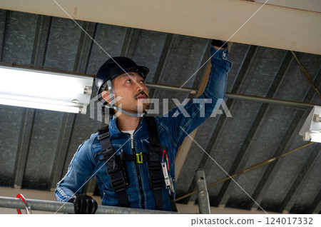 A man performing inspection work at a height A man performing inspection work at a height 124017332