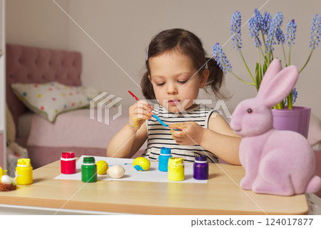 Little child girl paint Easter eggs at home. kid is preparing for Easter. Little child girl paint Easter eggs at home. kid is preparing for Easter. 124017877