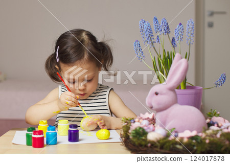Little child girl paint Easter eggs at home. kid is preparing for Easter. Little child girl paint Easter eggs at home. kid is preparing for Easter. 124017878
