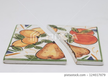 Cracked ceramic tile, broken into pieces, fragments of tiles. 124017879