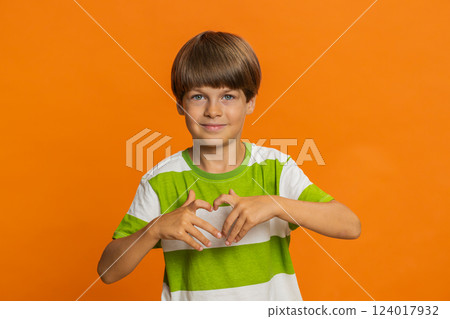 Smiling child boy makes heart gesture demonstrates love sign expresses good feelings and sympathy Smiling child boy makes heart gesture demonstrates love sign expresses good feelings and sympathy 124017932