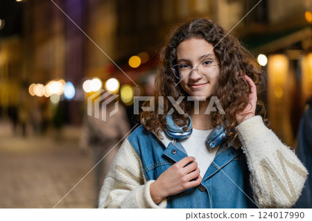 Portrait of happy pretty young woman girl smiling glad expression looking at camera in city street Portrait of happy pretty young woman girl smiling glad expression looking at camera in city street 124017990