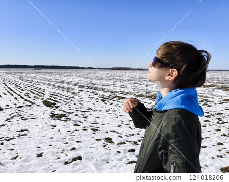 Closeup portrait of young cute caucasian teenager in sunglasses on a winter landscape background. concept of travel, youth, and hope. Dreamy teenage boy on the background of a winter landscape. 124018206