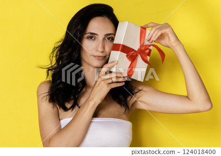 Woman holding white present box with red gift ribbon bow 124018400