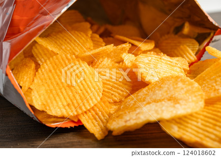 Potato chips, delicious BBQ seasoning spicy for crips, thin slice deep fried snack fast food in open bag. Potato chips, delicious BBQ seasoning spicy for crips, thin slice deep fried snack fast food in open bag. 124018602
