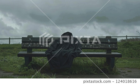 Empty Hoodie on Bench in Stormy Weather by Grass Field 124018616