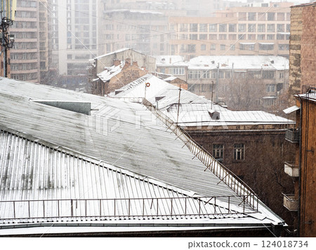 snow-covered roofs of buildings in snow in winter 124018734
