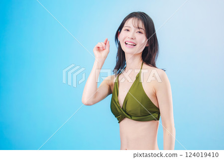 A woman enjoying summer in a swimsuit (light blue background) A woman enjoying summer in a swimsuit (light blue background) 124019410