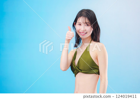 A woman enjoying summer in a swimsuit (light blue background) A woman enjoying summer in a swimsuit (light blue background) 124019411