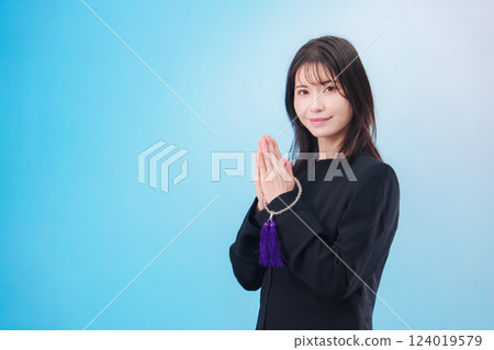 身穿喪服、雙手合十祈禱的婦女(淺藍色背景) 身穿喪服、雙手合十祈禱的婦女(淺藍色背景) 124019579