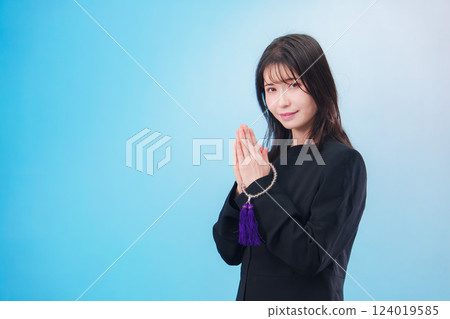 身穿喪服、雙手合十祈禱的婦女(淺藍色背景) 身穿喪服、雙手合十祈禱的婦女(淺藍色背景) 124019585