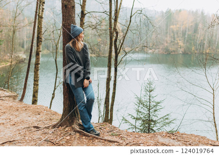 Fall autumn hiker woman outdoor at nature forest and lake for camping travel. Scenery of the majestic lake. Active lifestyle. Travel concept. High quality photo. Full body 124019764