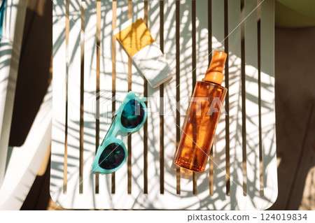 Sunscreens, sunglasses and a delicious chilled cocktail on the pool table 124019834