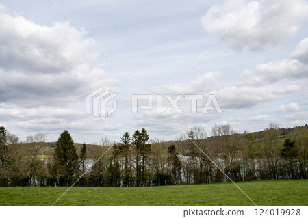 Fields, lawns and winter foliage seen from a hilltop under a cloudy sky in the Valley of the Ouse, outside London 124019928