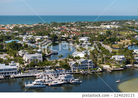 Wealthy neighborhood in small town Boca Grande, Florida with expensive waterfront houses between green palm trees. Development of US premium housing 124020115