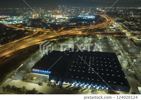View from above of many parked cars on illuminaded parking lot with lines and markings for parking places and directions. Place for vehicles in front of a shopping mall center View from above of many parked cars on illuminaded parking lot with lines and markings for parking places and directions. Place for vehicles in front of a shopping mall center 124020124