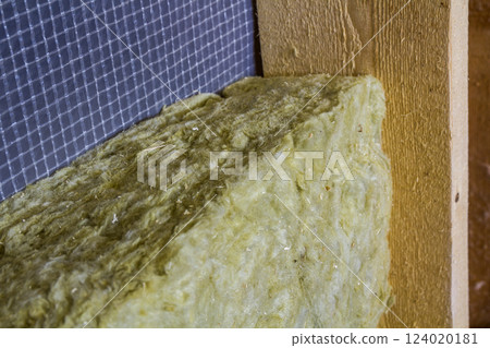 Thermal insulation mineral rock wool installation at the new building attic wall Thermal insulation mineral rock wool installation at the new building attic wall 124020181