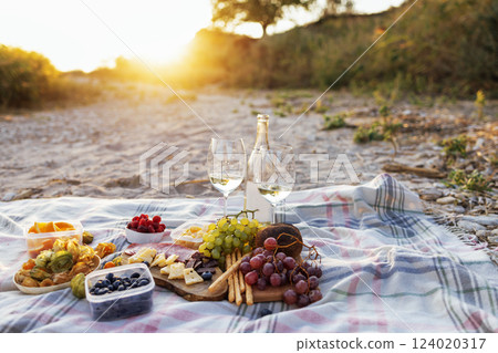 Close-up of  a bottle of white wine into glasses outdoors 124020317