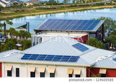 Solar rooftops on commercial center in Florida. Photovoltaic panels for producing of clean ecological electrical energy in city urban area. Concept of autonomous building Solar rooftops on commercial center in Florida. Photovoltaic panels for producing of clean ecological electrical energy in city urban area. Concept of autonomous building 124020589