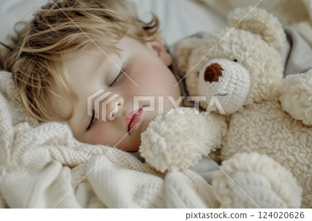 Child peacefully sleeping while cuddling a fluffy teddy bear in a cozy bedroom setting during the afternoon Child peacefully sleeping while cuddling a fluffy teddy bear in a cozy bedroom setting during the afternoon 124020626
