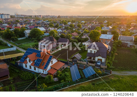 Residential house with rooftop covered with solar photovoltaic panels for producing of clean ecological electrical energy in suburban rural area. Concept of autonomous home Residential house with rooftop covered with solar photovoltaic panels for producing of clean ecological electrical energy in suburban rural area. Concept of autonomous home 124020648