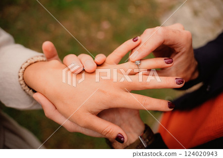 Man places engagement ring on his beloved's hand 124020943